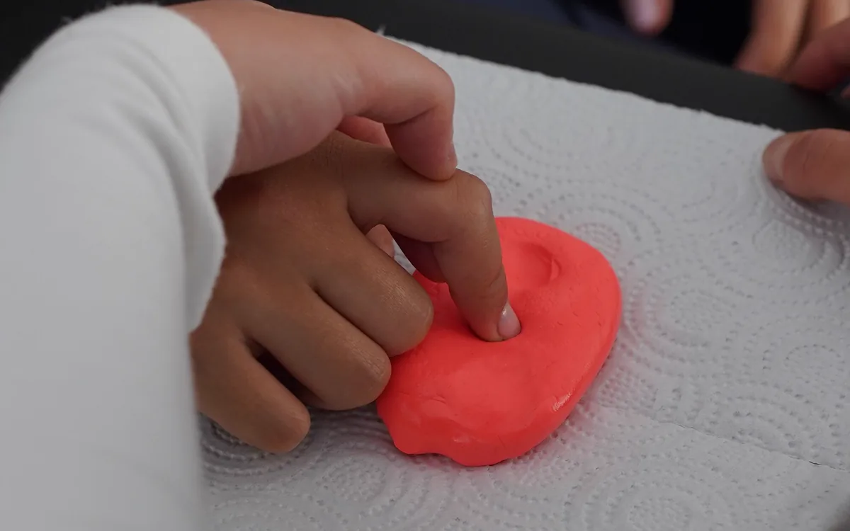 Profesional guiando una actividad sensorial con plastilina